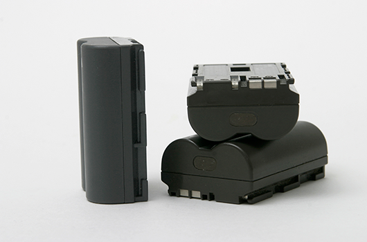 Three lithium-ion battery packs of different sizes standing apart from one another
